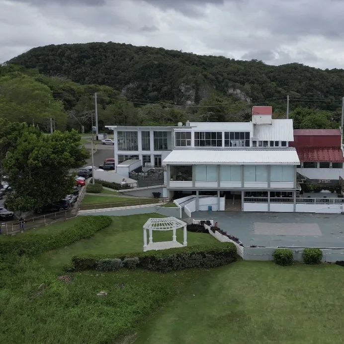 Aerial drone photo of a property shot by Zoom Realty Services, with Puerto Rico's mountains in the background