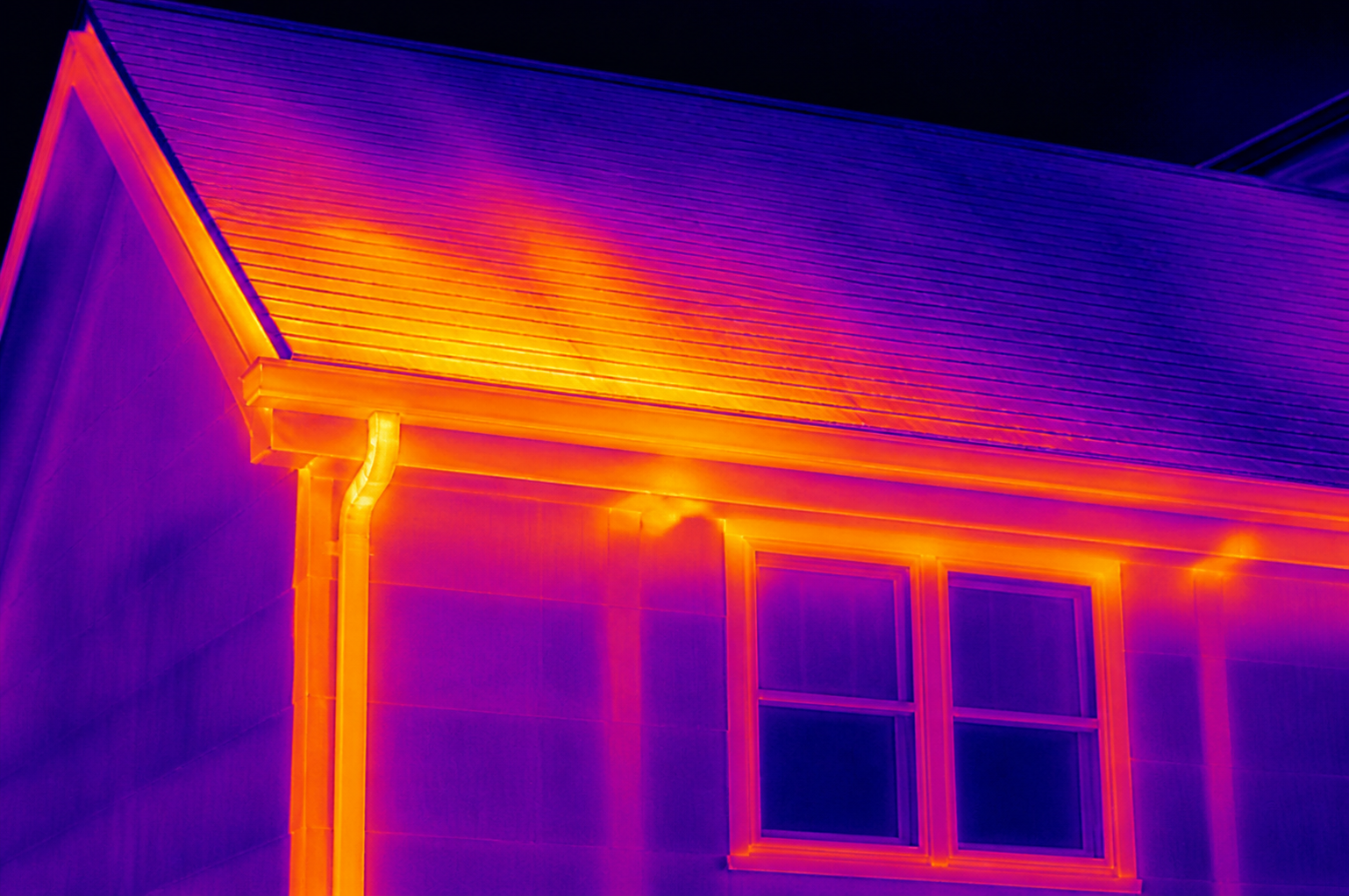 Infrared thermal view showing temperature differences across a residential roof and exterior wall
